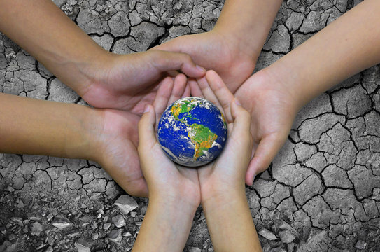 Earth planet in asian Children hand isolated on Ground arid barren