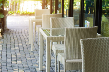 White rattan chair and table decoration in restaurant , process in sun light filter effect