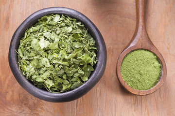 Leaves and moringa powder on wood (moringa oleifera)