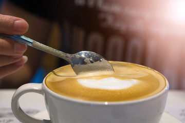 Coffee spoon is in a coffee mug.