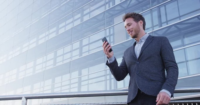 Video chat business meeting concept. Businessman talking on phone having video conference conversation using smart phone app on smartphone smiling happy wearing suit jacket. Urban male professional