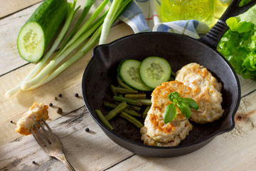 Meat cutlet from minced meat, served in a cast-iron frying pan with green beans kitchen table in a rustic style. Copy space.