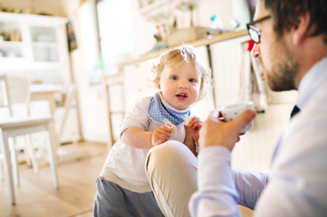 Businessman with his little son at home, drinking coffee.
