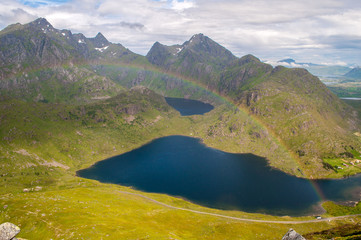 Pointed mountains with lake and rainbow - Lofoten, Norway