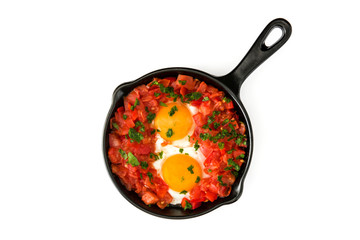 Shakshuka in iron frying pan isolated on white background. Typical food in Israel.
