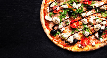  Pizza with mozzarella, 4 cheese, olives, leaves, goat cheese and balsamic sauce  top view with copy space for restaurant menu on black background. .