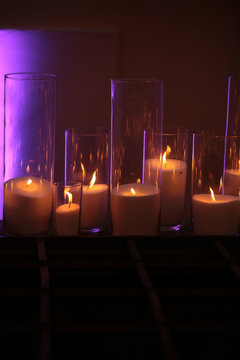 Burning candles of white wax with flame reflection