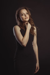 Fototapeta premium Beautiful female model with lush brunette hair posing at studio