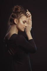 Portrait of tender brunette woman in the dark room