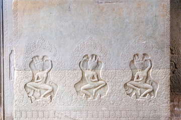 Dancing Apsaras an old Khmer art carvings on the wall in the corridors of Angkor Wat temple near Siem Reap town, Cambodia.
