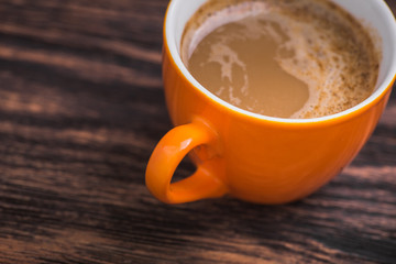 orange coffee cup on old wooden table