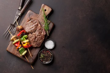Deurstickers Grilled vegetables and beef steak on cutting board © karandaev