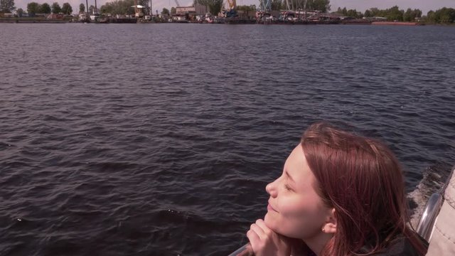 Young girl on a boat enjoys fresh sea air 4K UHD slowmo