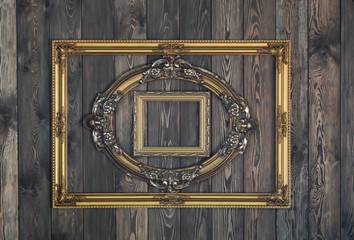 Old, victorian, gilt, elegant frame on a wooden wall, baroque, rococo, the Renaissance