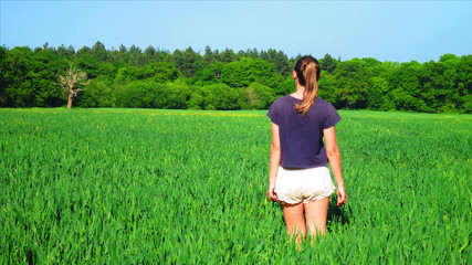 Young Caucasian White Woman in Barley Farm Field on a Sunny Blue Sky Day, England, UK