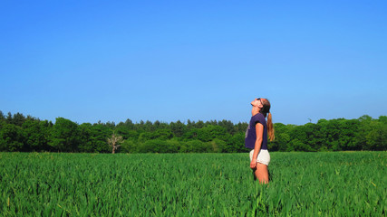 Young Caucasian White Woman in Barley Farm Field on a Sunny Blue Sky Day, England, UK