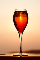 Aperol spritz at a wooden pier at sunset. Luxury resort vacation concept. Festive relax getaway background.