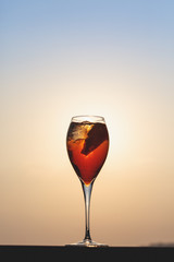 Aperol spritz at a wooden pier at sunset. Luxury resort vacation concept. Festive relax getaway background.