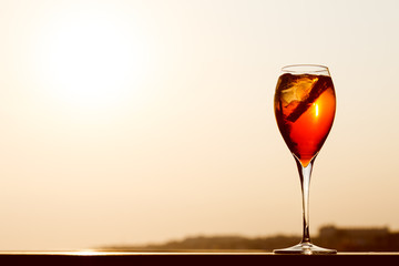 Aperol spritz at a wooden pier at sunset. Luxury resort vacation concept. Festive relax getaway background.
