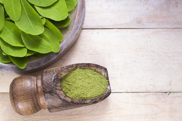 Leaves and moringa powder on wood (moringa oleifera)
