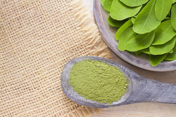 Leaves and moringa powder on wood (moringa oleifera)