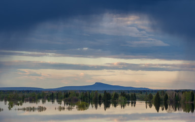 Spring landscape, mountain on background. Rainy day