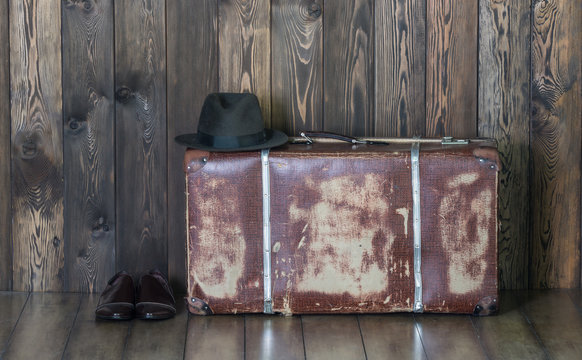 Old suitcase, vintage shoes and hat, old wooden wall
