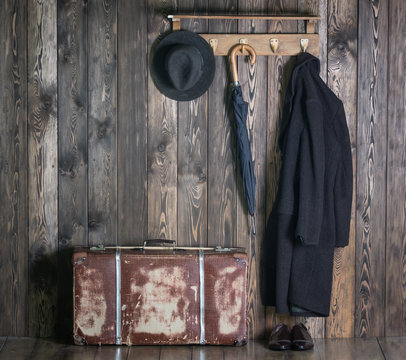Hanger with clothes, old suitcase