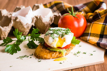Sandwich with poached egg, tomato and egg shells