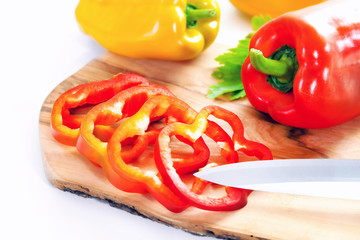 Whole and sliced peppers, red and yellow pepper. Raw vegetable.