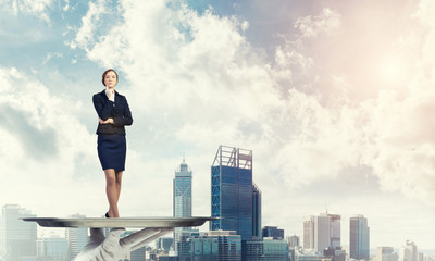 Confident elegant businesswoman presented on metal tray against cityscape background