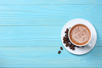 coffee cup with coffee beans on blue wooden background. top view with copy space