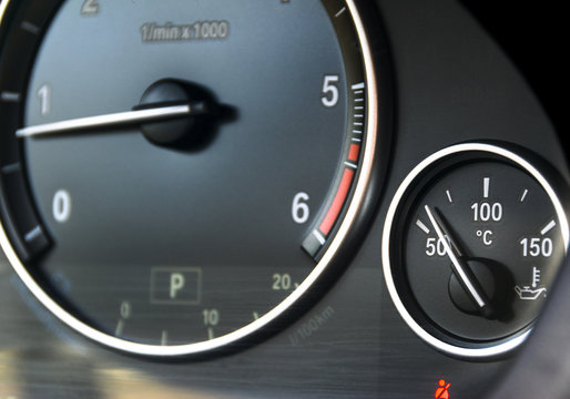 Coolant temperature gauge and tahometer on a car's dashboard. Car interior details. Close up view