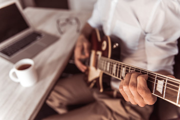 Handsome businessman playing guitar