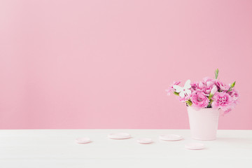 bouquet of pink Carnation flowers in vase on pink background. Empty space for text