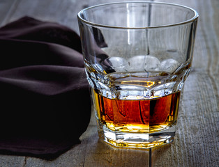 A glass of alcohol on an old wooden table