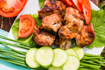 Шашлык со свежими овощами на тарелке