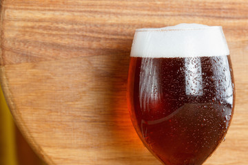 Beer glass pint with copy-space on wooden background.