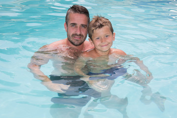 father and son happy in summer pool house