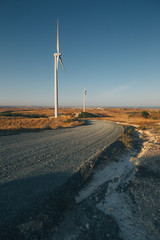 Two windmills by roadside in a rural landscape in Cyprus