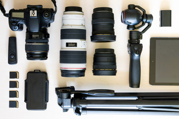 Top view of collection of photograph equipment with camera, camcorder, lens and tripod