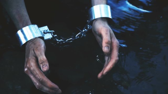 prisoner in handcuffs washes hands and gathers water to drink