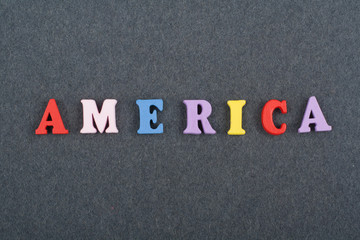 America word on black board background composed from colorful abc alphabet block wooden letters, copy space for ad text. Learning english concept