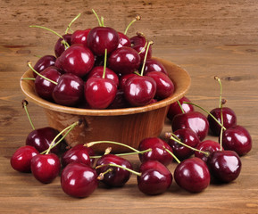 Cherries in a wooden bowl on a wooden background