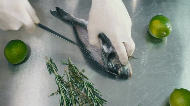 Portrait of a process of cleaning a fish with a knife
