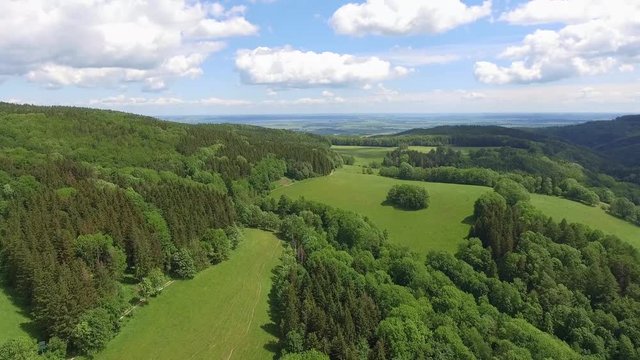 Aerial view of the summer time in mountains near Czarna Gora mountain in Poland. Pine tree forest and clouds over blue sky. View from above.