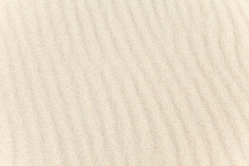 Fototapeta na wymiar The wavy texture of the sand on the beach. The background image. Top view