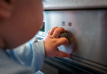 Obraz premium dangerous situation, the child is playing with an electric stove.