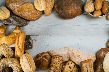 Assortment of baked bread on wooden rustic table background