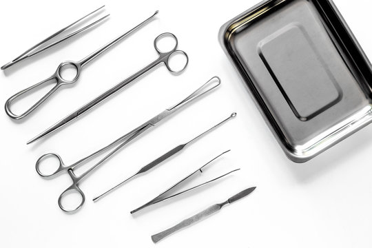 Surgical instruments and tools including scalpels, forceps and tweezers on white table top view mock up